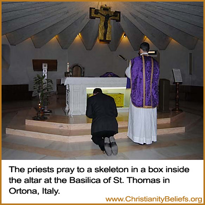 Catholic priests pray to a skeleton in a box inside the altar at the Basilica of St. Thomas in Ortona, Italy