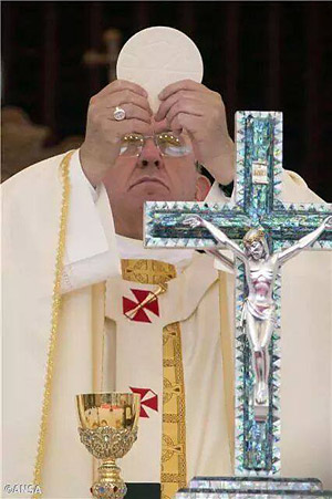 Pope Francis revering eucharist wafer sun god