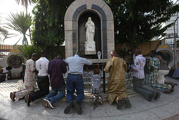 Catholic faithful pray at a statue of the Virgin Mary after a morning mass, at the Church of the Assumption in Lagos, Nigeria.